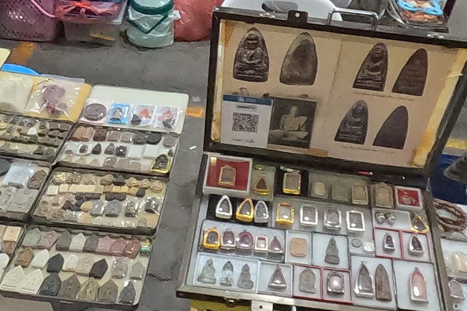 ถาดพระดินและกรอบแสดงพระ · Trays of clay amulets and a framed display