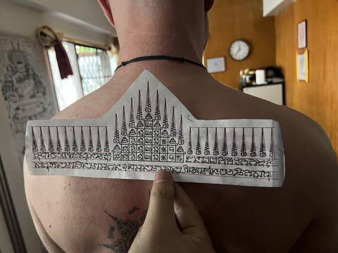 The template inked and pressed onto the back before the work starts, at Sak Yant Chiang Mai.
