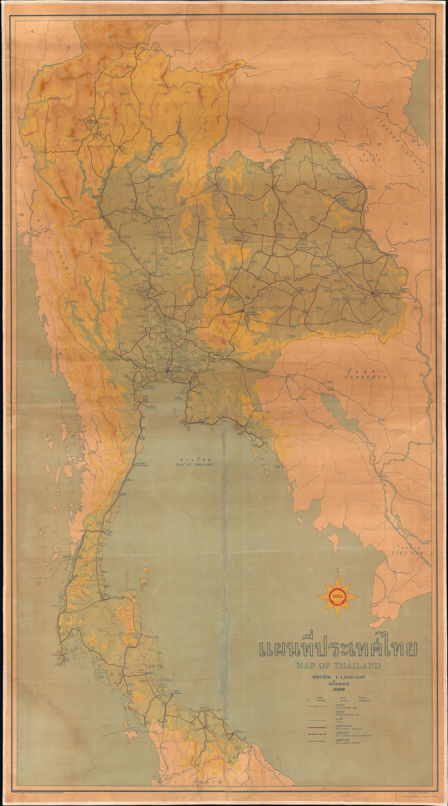 A large bilingual wall map of Thailand, circa 1958 (undated). It features infrastructure (highways, railways), cities, towns, topographic detail. A compass with the shell logo is above the map title.