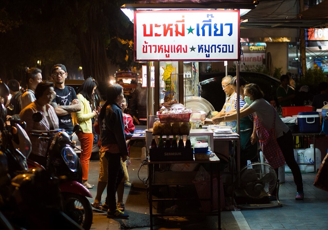 A popular street food stall in Chiang Mai on Manee Nopparat road. It is known for its red roast pork, crispy pork, and wontons; either served with rice or in a