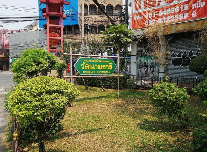 Namdhari Gurudwara Hindu Tempel naambord in een klein plantsoentje bij de hoofdingang