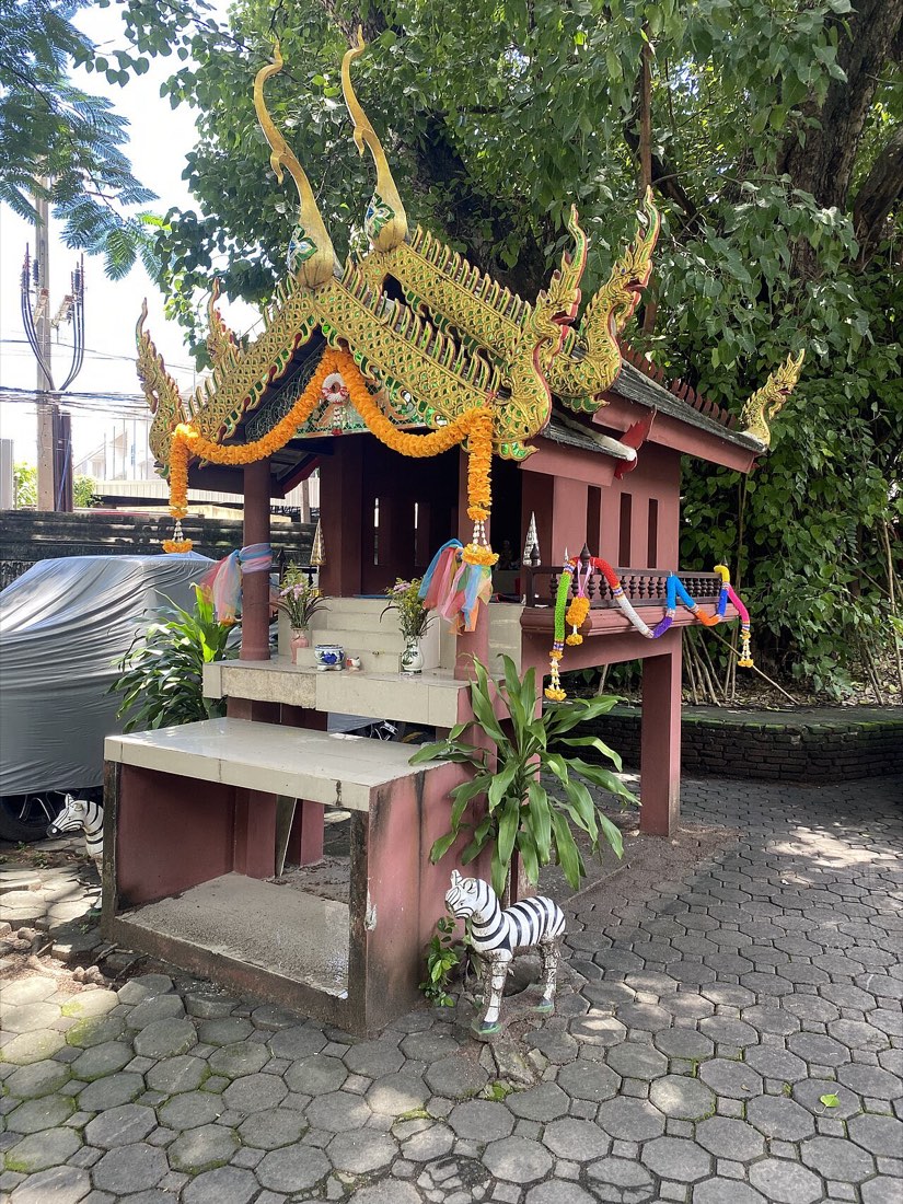 ศาลเจ้าที่หลังใหญ่ ประดับดอกดาวเรือง · a large roadside shrine dressed in marigold garlands