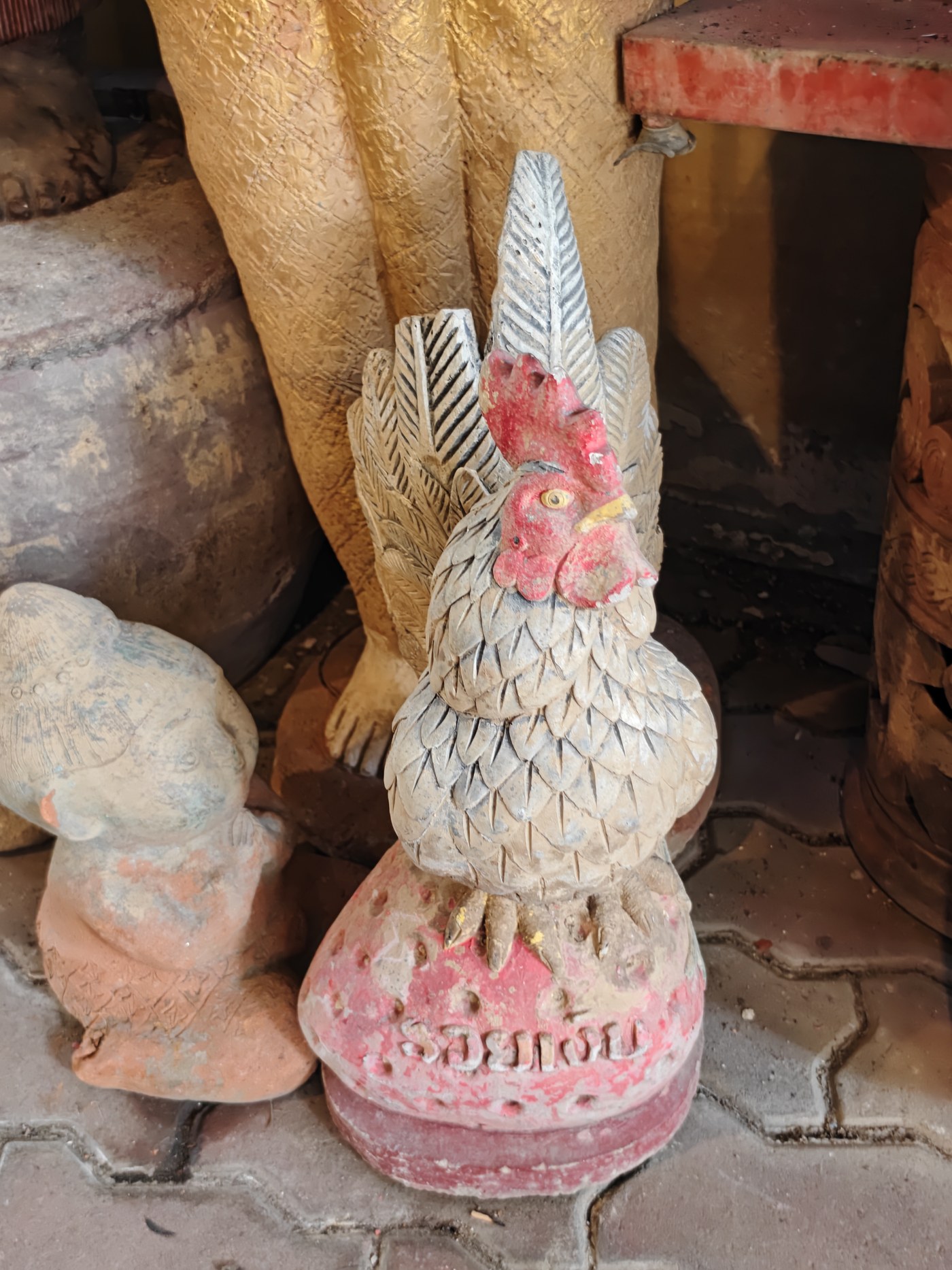 A carved rooster offering at the Garden