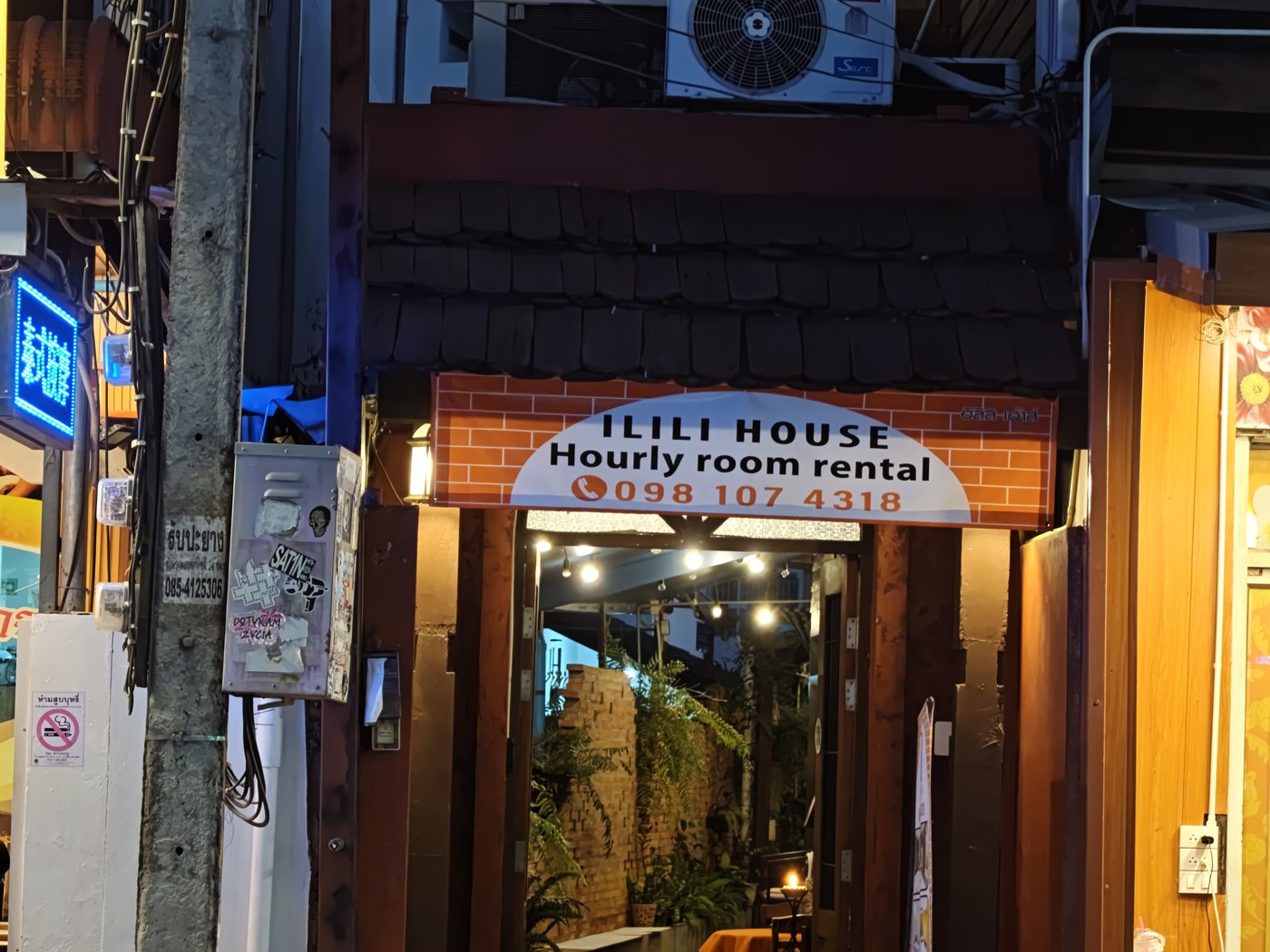 Ilili House at night: 'Hourly room rental' over the door