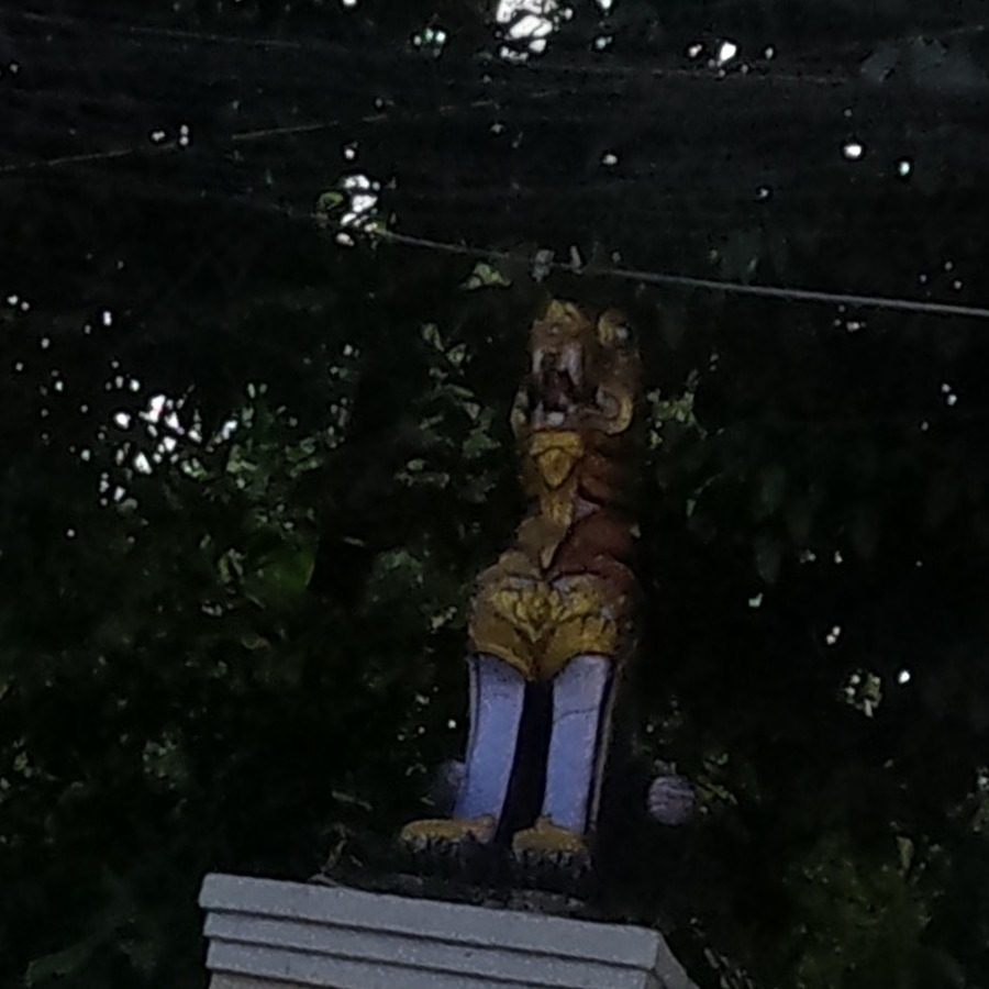 Gilded guardian statue on the temple wall