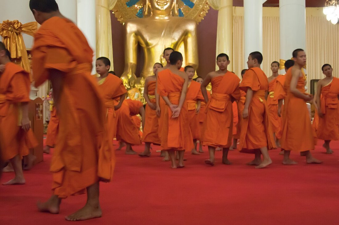 Buddhist monks in orange robes. Wat Chedi Luang. Buddhist temple in the historic centre of Chiang Mai, Thailand.