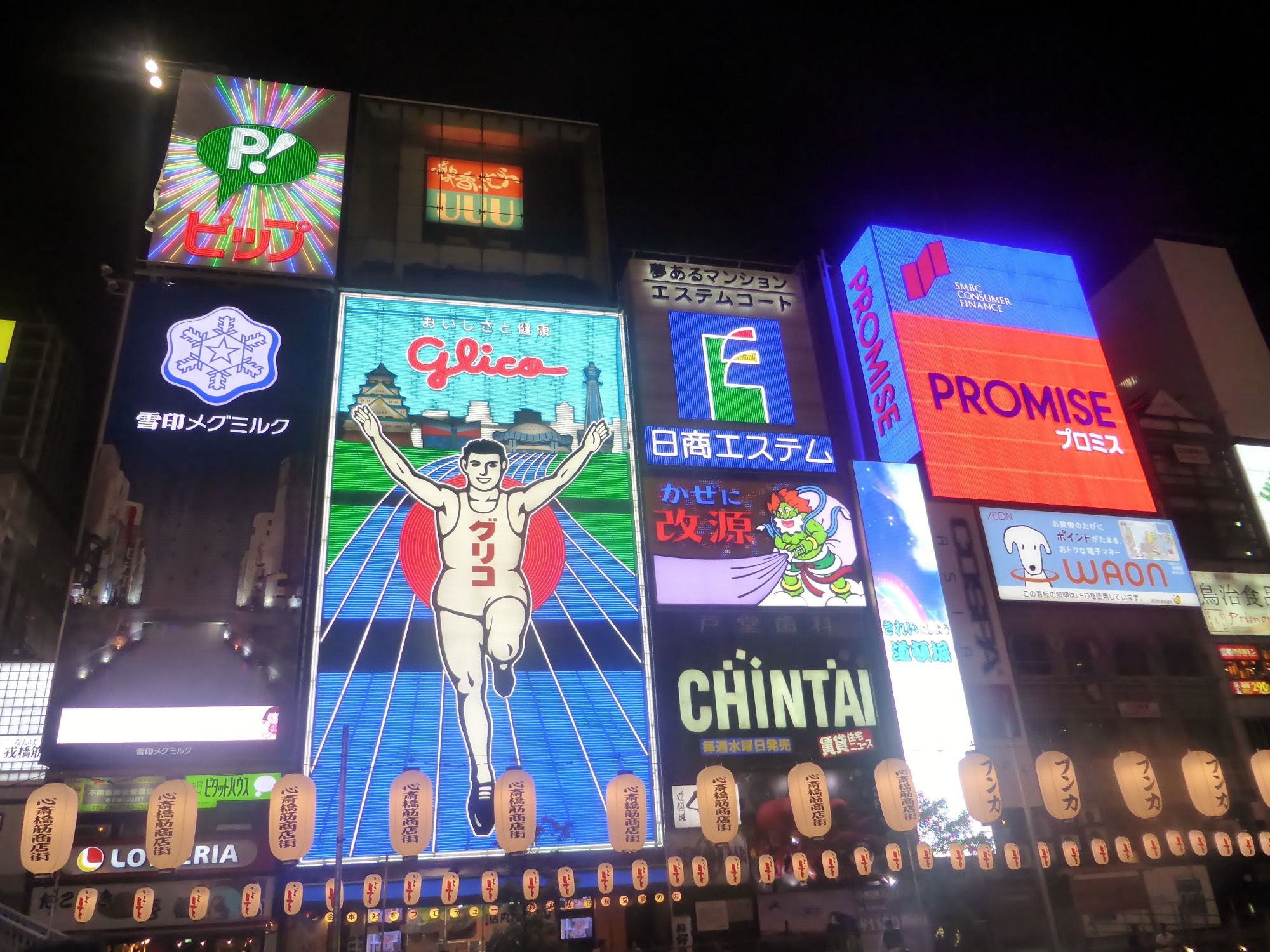 Neon signs over the canal at Dotonbori at night, the Glico running man among them