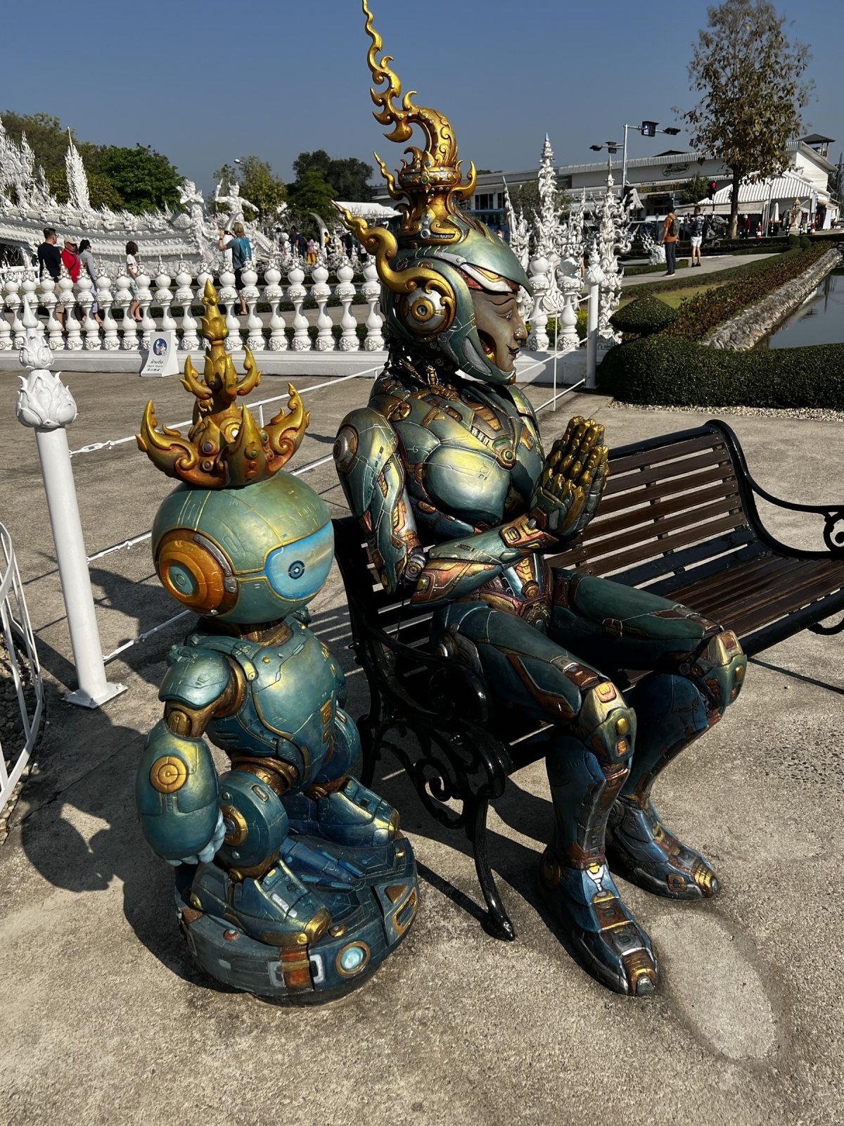 Robots on a bench by the white temple.