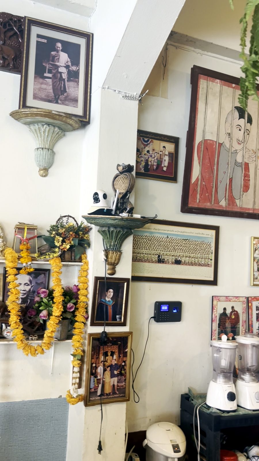 ชั้นพวงมาลัยกับรูปภาพ · A shelf of garlands and pictures