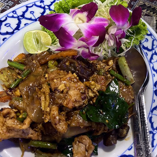 ผัดเส้นใหญ่บนจานลายคราม · stir-fried wide noodles on a blue-and-white plate