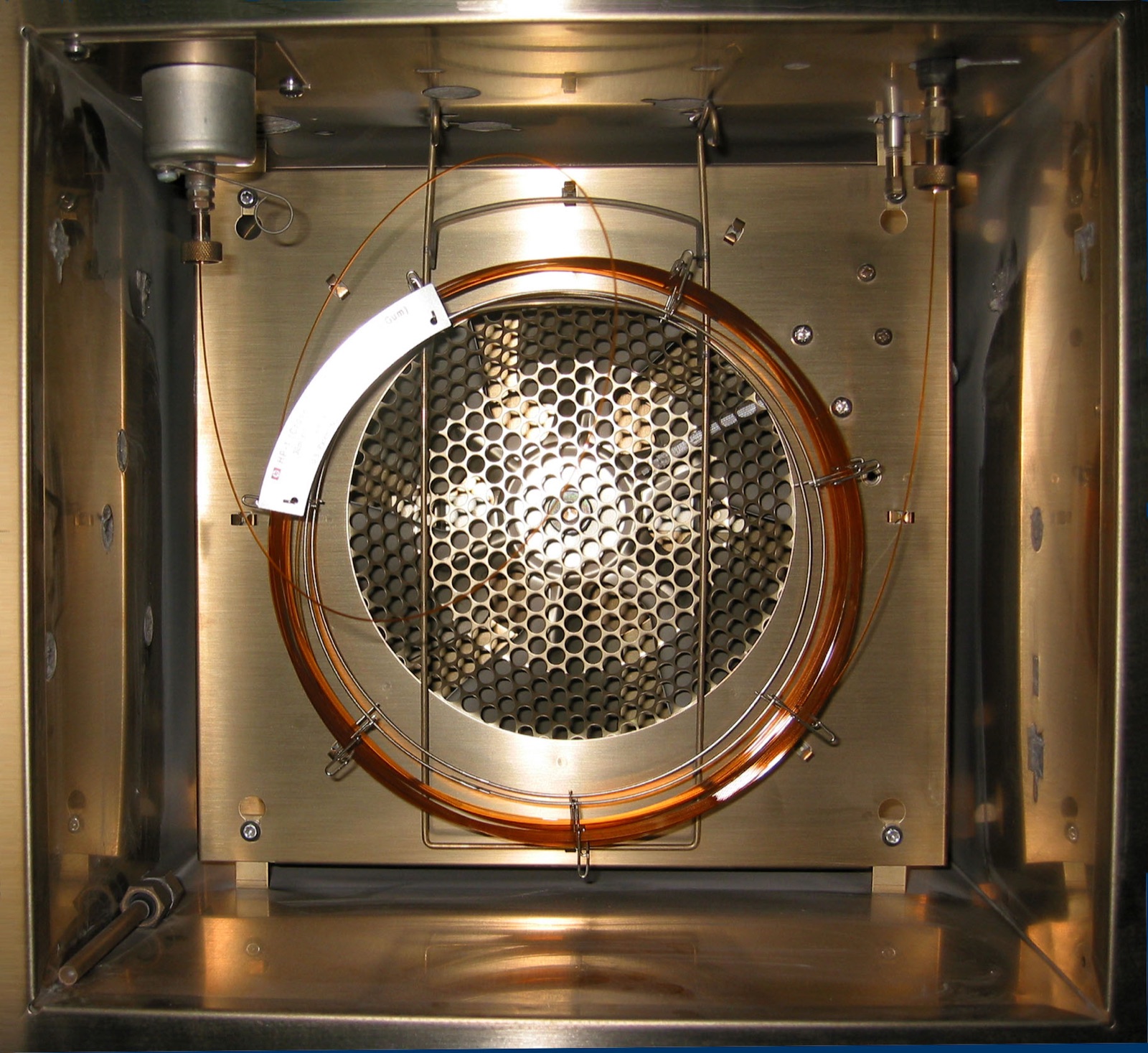 Inside the GC oven: the capillary column is the thin coil on the round cage.