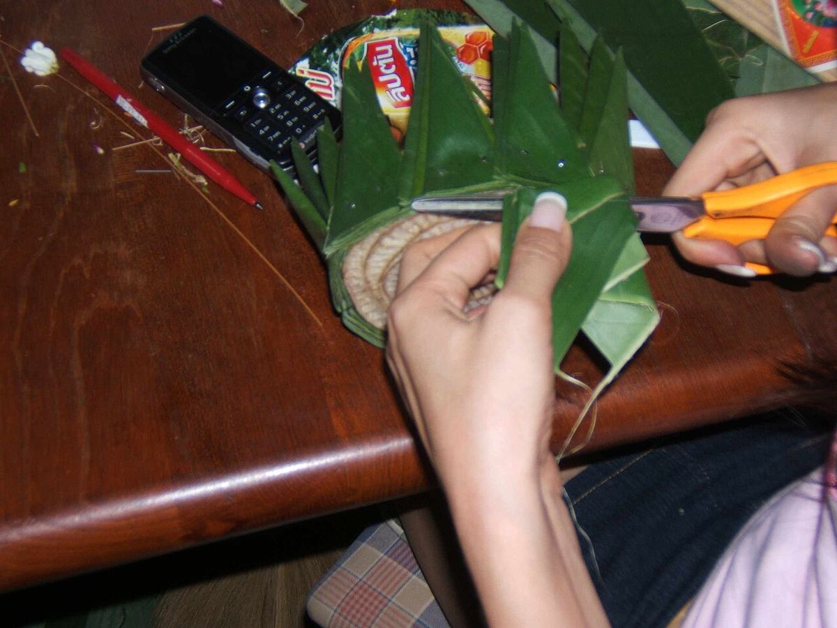 Folding banana-leaf petals onto a slice of trunk, 2005.