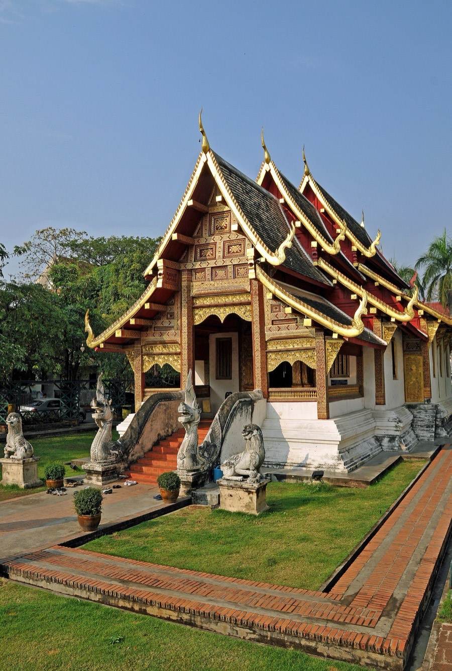 The tiered roofs of Viharn Lai Kham over its white base.