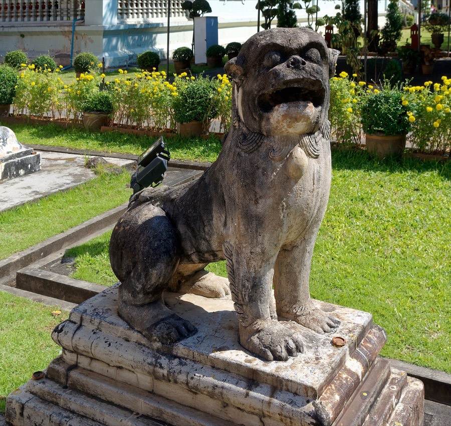 A stone singha sits on its pedestal.