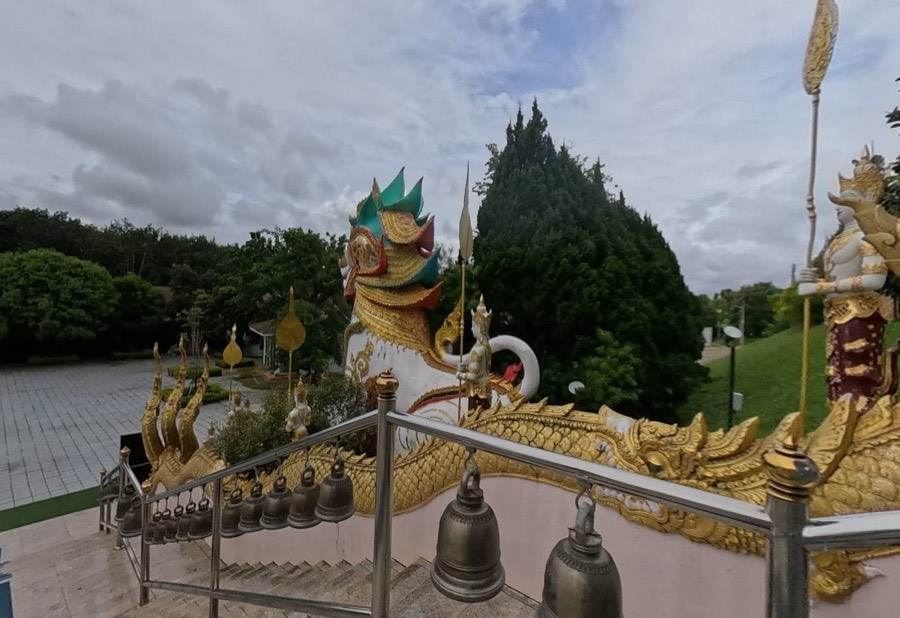 A naga rail hung with bells, a guardian lion at its end.