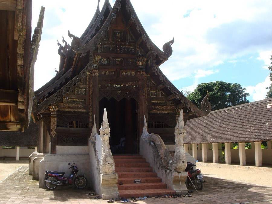 The teak viharn of Ton Kwen with a naga on its stair.
