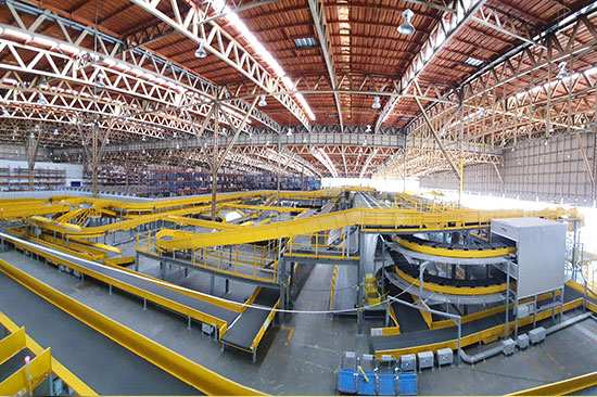 Yellow conveyor belts and spiral chutes inside a Flash Express sorting hall