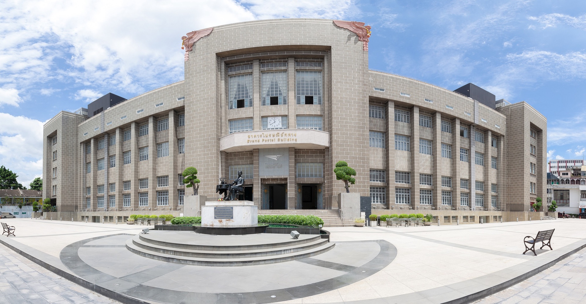 The Bangkok General Post Office, a tall stone building behind a round plaza