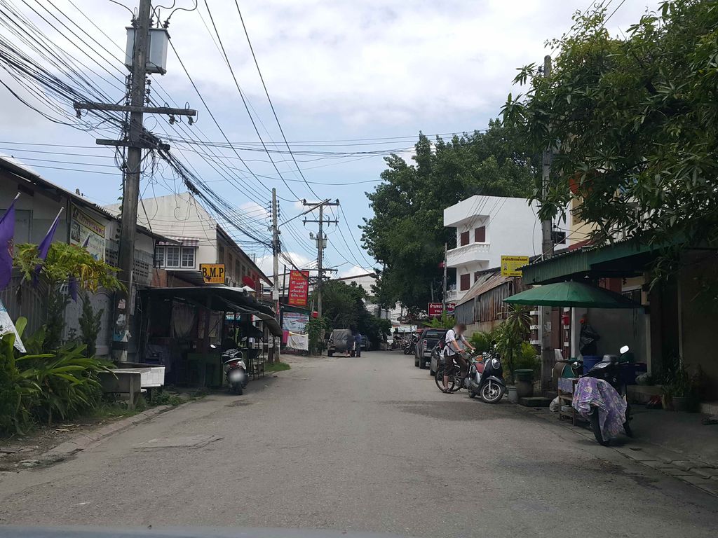 ภาพถนนตรงที่ ร้านนารี ตัดเสื้อแก้ทรง ตั้งอยู่ ถ่ายโดย jrcarlsen พ.ศ. 2558 (2015) · A street-level view of where ร้านนารี ตัดเสื้อแก้ทรง · Ran Na Ri Tat Suea Kaesong stands, by jrcarlsen in 2558 (2015)
