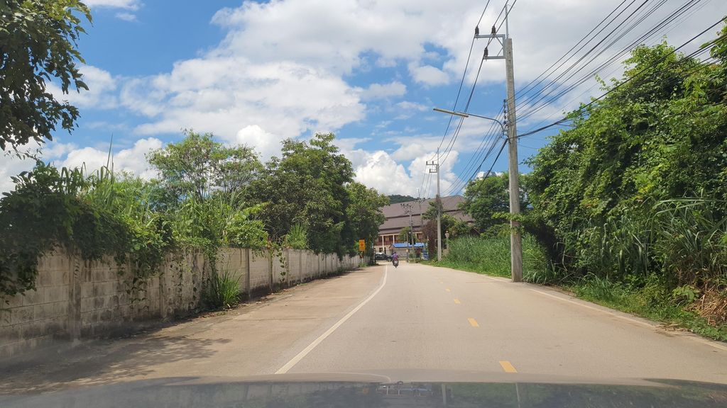 ภาพถนนตรงที่ ฌาปนสถานบ้านป่าจี้ ตั้งอยู่ ถ่ายโดย jrcarlsen พ.ศ. 2564 (2021) · A street-level view of where ฌาปนสถานบ้านป่าจี้ · Chapnotthan Ban Pa Chi stands, by jrcarlsen in 2564 (2021)