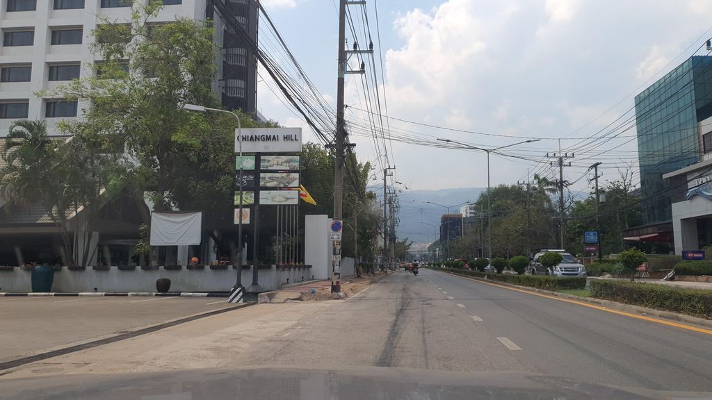 ภาพถนนตรงที่ ที่จอดรถ · นอกเวียง ทางตะวันตกเฉียงเหนือ ห่างคูเมือง 2.1 กม. ตั้งอยู่ ถ่ายโดย jrcarlsen พ.ศ. 2566 (2023) · A street-level view of where Parking · Outside the moat to the north-west, 2.1 km from the water stands, by jrcarlsen in 2566 (2023)