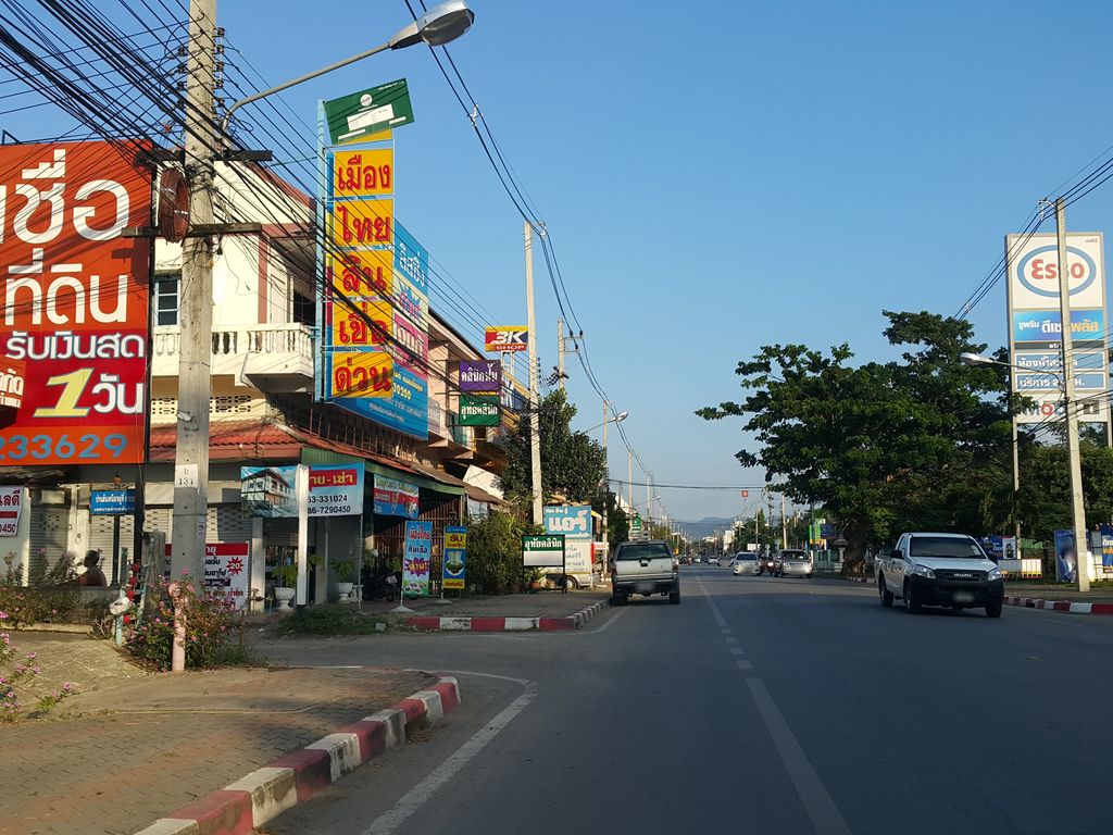 ภาพถนนตรงที่ กล่องไปรษณีย์ เชียงใหม่ สันกำแพง ตั้งอยู่ ถ่ายโดย jrcarlsen พ.ศ. 2558 (2015) · A street-level view of where กล่องไปรษณีย์ เชียงใหม่ สันกำแพง · Kalong Praisani Chiang Mai San Kamphaeng stands, by jrcarlsen in 2558 (2015)