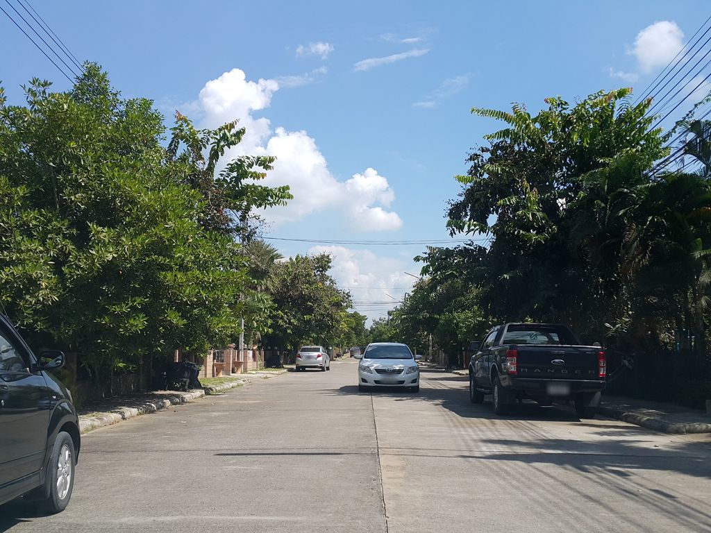 ภาพถนนตรงที่ หมู่บ้าน สิรินโฮม2 ตั้งอยู่ ถ่ายโดย jrcarlsen พ.ศ. 2558 (2015) · A street-level view of where หมู่บ้าน สิรินโฮม2 · Sirinhom2 Village stands, by jrcarlsen in 2558 (2015)