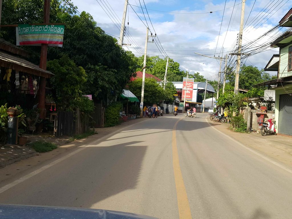 ภาพถนนตรงที่ ผ้าตีนจกแม่แจ่ม ร้านเฮือนคำอ่อน จำหน่ายปลีก-ส่ง ตั้งอยู่ ถ่ายโดย jrcarlsen พ.ศ. 2558 (2015) · A street-level view of where ผ้าตีนจกแม่แจ่ม ร้านเฮือนคำอ่อน จำหน่ายปลีก-ส่ง · Pha Tinchok Mae Chaem Ran Hueankham On Chamnaiplik-song stands, by jrcarlsen in 2558 (2015)