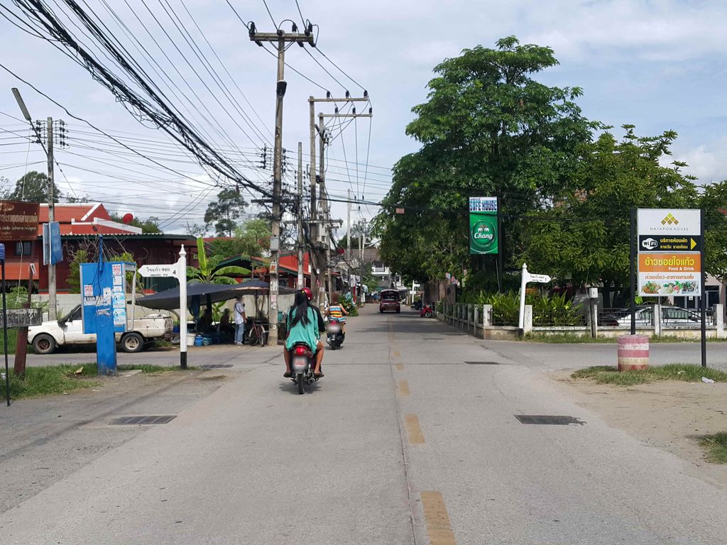ภาพถนนตรงที่ ตลาดนัดวันศุกร์ ชุมชนใจแก้ว ตั้งอยู่ ถ่ายโดย jrcarlsen พ.ศ. 2558 (2015) · A street-level view of where ตลาดนัดวันศุกร์ ชุมชนใจแก้ว · Nat Wansu Chumchon Chaikwae Market stands, by jrcarlsen in 2558 (2015)