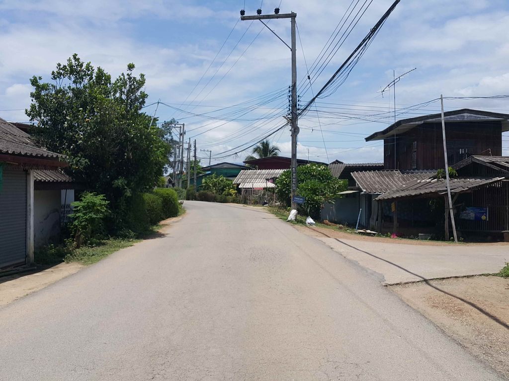 ภาพถนนตรงที่ โรงน้ำดื่มโชคนิภา ตั้งอยู่ ถ่ายโดย jrcarlsen พ.ศ. 2558 (2015) · A street-level view of where โรงน้ำดื่มโชคนิภา · Rongnamduem Chok Ni Pha stands, by jrcarlsen in 2558 (2015)