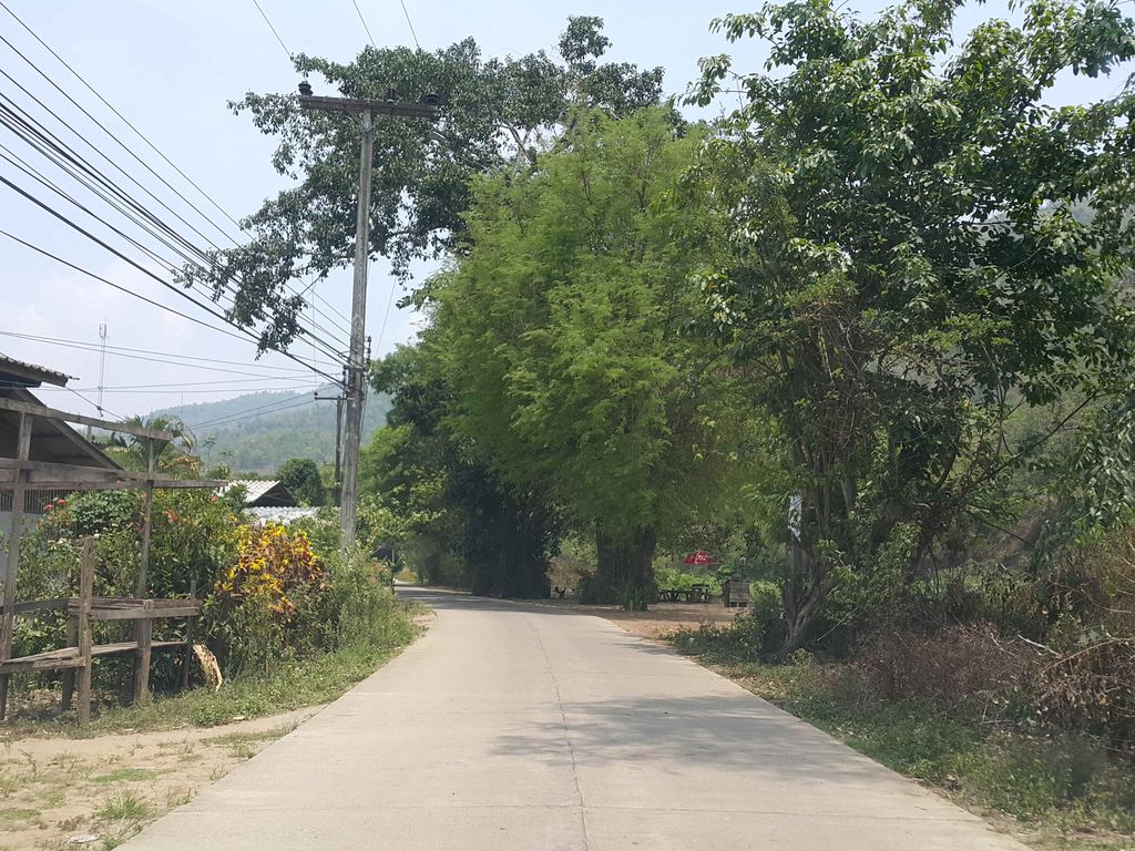 ภาพถนนตรงที่ The River Flows Kued Chang Camp ตั้งอยู่ ถ่ายโดย jrcarlsen พ.ศ. 2558 (2015) · A street-level view of where The River Flows Kued Chang Camp stands, by jrcarlsen in 2558 (2015)