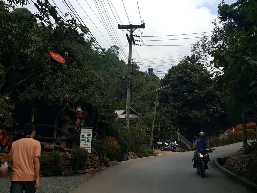ภาพถนนตรงที่ เฮือนบอกฮัก แม่กำปอง ตั้งอยู่ ถ่ายโดย jrcarlsen พ.ศ. 2558 (2015) · A street-level view of where เฮือนบอกฮัก แม่กำปอง · Hueanbokhak Mae Kam Pong stands, by jrcarlsen in 2558 (2015)